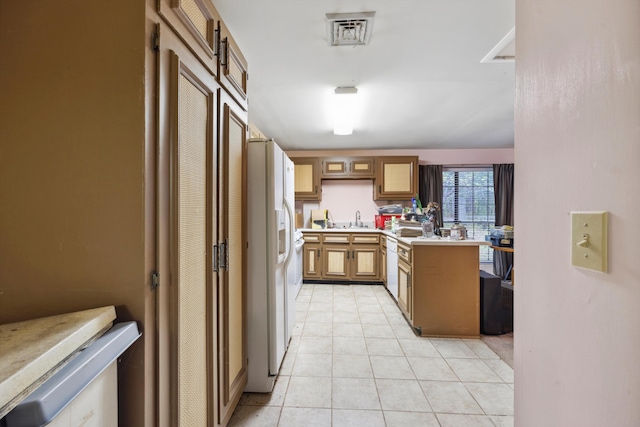 kitchen featuring white refrigerator with ice dispenser, light tile patterned flooring, sink, and dishwasher