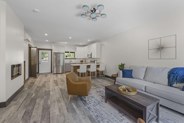 living room with light hardwood / wood-style floors, an AC wall unit, and heating unit