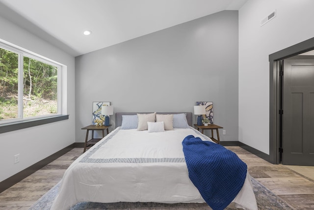 bedroom with hardwood / wood-style floors and vaulted ceiling