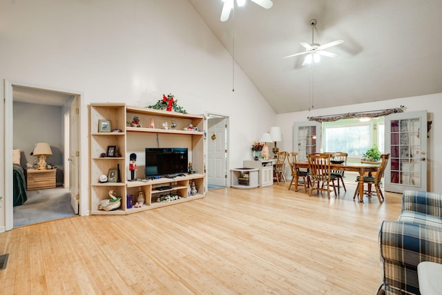 living room featuring ceiling fan, high vaulted ceiling, and light wood-type flooring