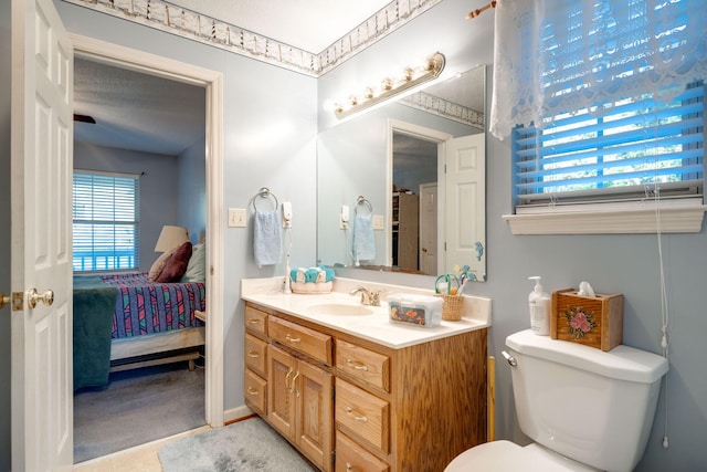 bathroom with toilet, a textured ceiling, and vanity