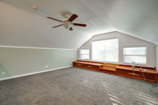 additional living space with lofted ceiling, a textured ceiling, carpet flooring, and ceiling fan