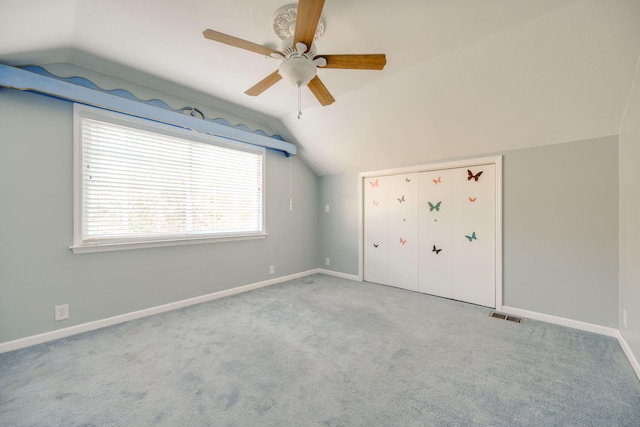 unfurnished bedroom with vaulted ceiling, light colored carpet, and ceiling fan