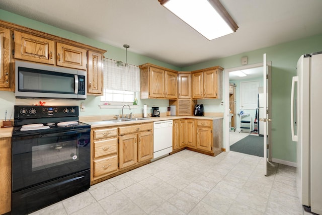 kitchen with sink, pendant lighting, and white appliances