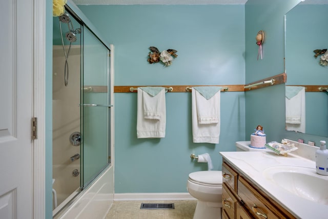 full bathroom featuring vanity, shower / bath combination with glass door, toilet, and tile patterned floors