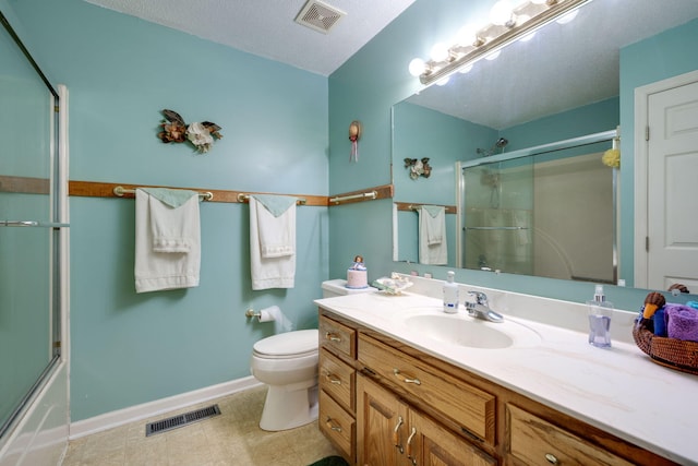 bathroom with vanity, a textured ceiling, toilet, and tile patterned flooring