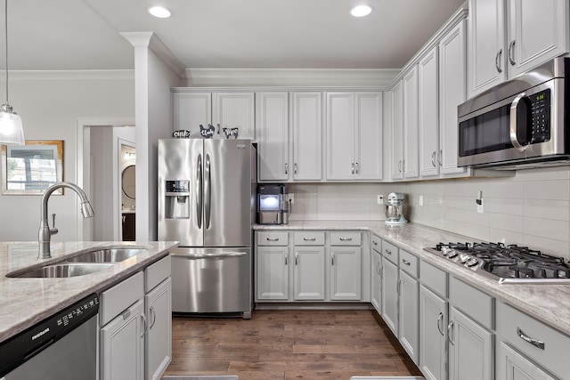 kitchen featuring light stone counters, dark wood-type flooring, sink, stainless steel appliances, and decorative light fixtures