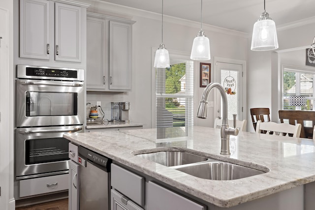 kitchen featuring appliances with stainless steel finishes, ornamental molding, sink, and light stone counters