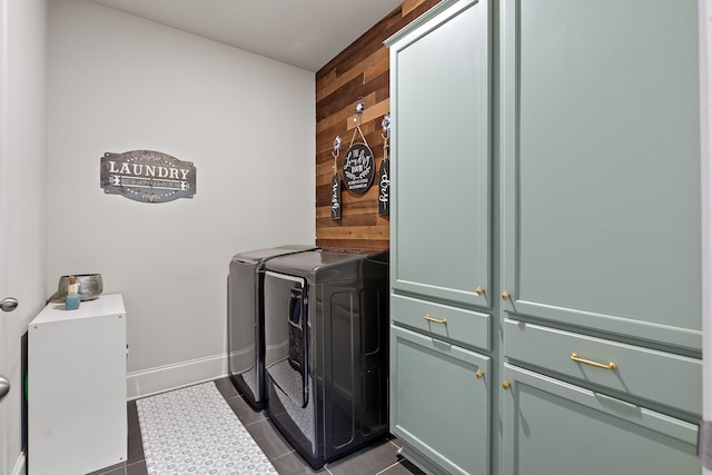 washroom with cabinets, wood walls, separate washer and dryer, and tile patterned floors