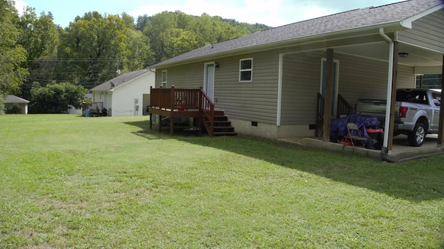 back of house featuring a carport and a yard