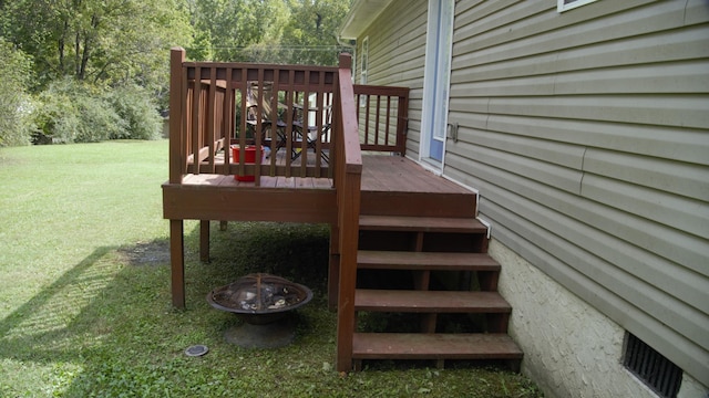 wooden terrace with a yard and an outdoor fire pit