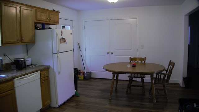 kitchen with white appliances and dark hardwood / wood-style flooring