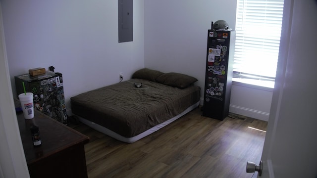 bedroom with wood-type flooring and electric panel