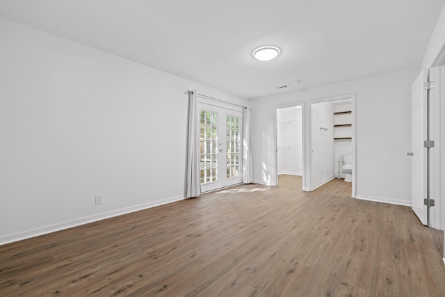 unfurnished bedroom with light hardwood / wood-style flooring, a closet, and a walk in closet