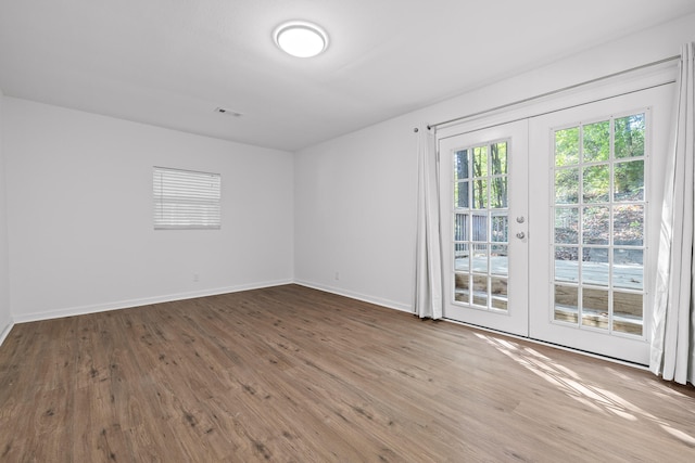 spare room with wood-type flooring and french doors