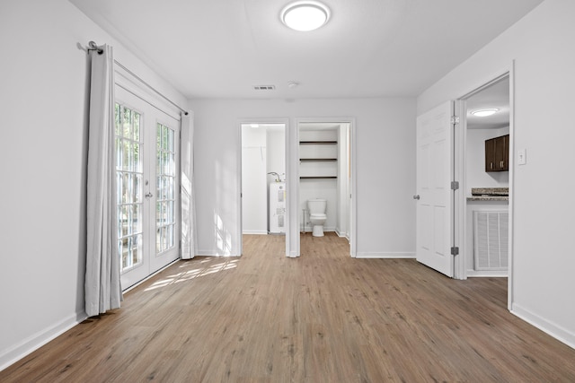 unfurnished living room featuring french doors and light hardwood / wood-style floors