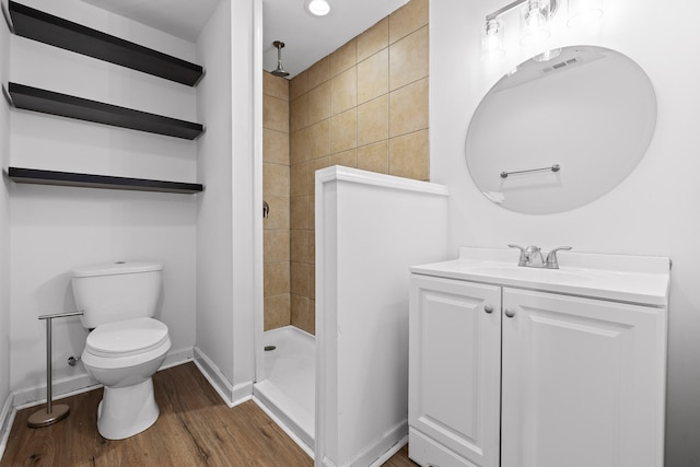 bathroom with walk in shower, hardwood / wood-style floors, vanity, and toilet