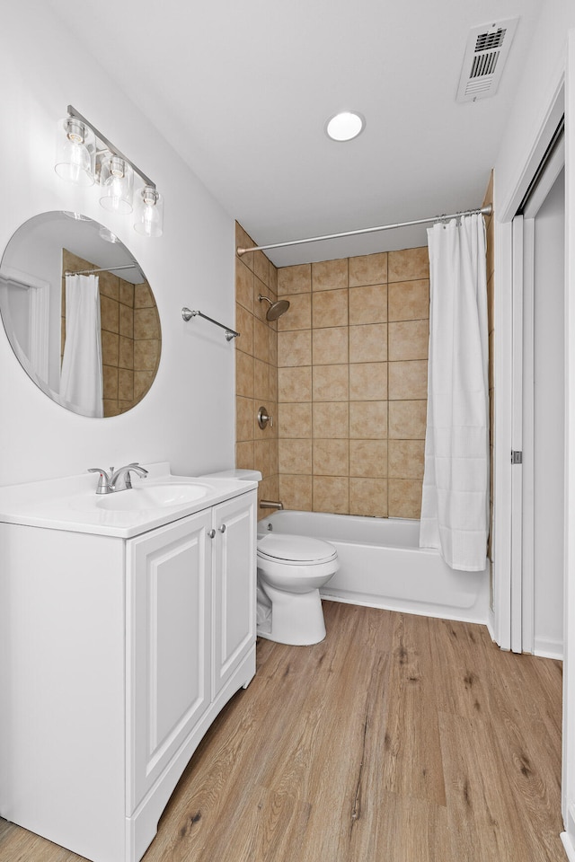 full bathroom featuring vanity, toilet, shower / bathtub combination with curtain, and hardwood / wood-style flooring