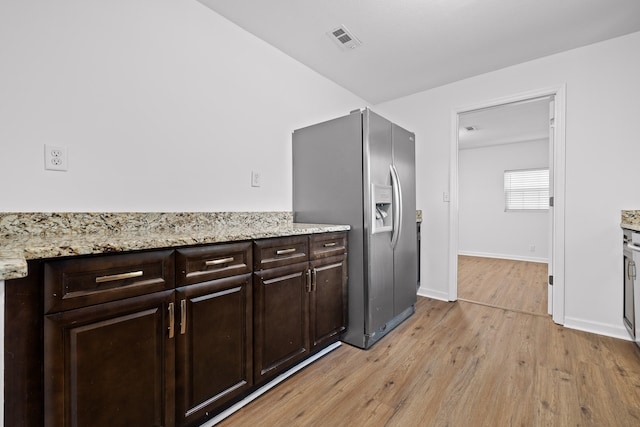 kitchen featuring light hardwood / wood-style floors, dark brown cabinets, stainless steel fridge with ice dispenser, and light stone counters