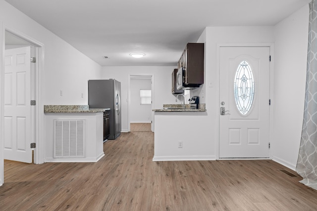 kitchen with light wood-type flooring, a healthy amount of sunlight, and stainless steel appliances