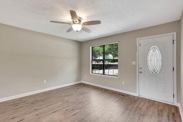 entrance foyer with ceiling fan, a textured ceiling, and light hardwood / wood-style flooring