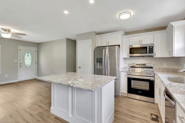 kitchen featuring light hardwood / wood-style flooring, stainless steel appliances, and white cabinets