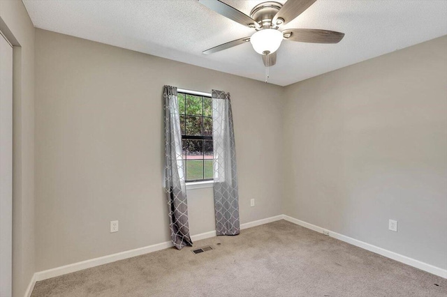 carpeted spare room with a textured ceiling and ceiling fan