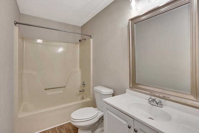 full bathroom with bathing tub / shower combination, vanity, a textured ceiling, wood-type flooring, and toilet