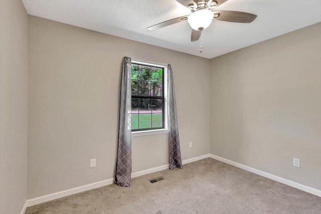 carpeted empty room featuring ceiling fan and a textured ceiling