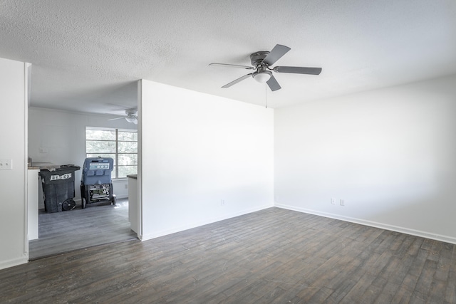 spare room with a textured ceiling, ceiling fan, and dark hardwood / wood-style flooring