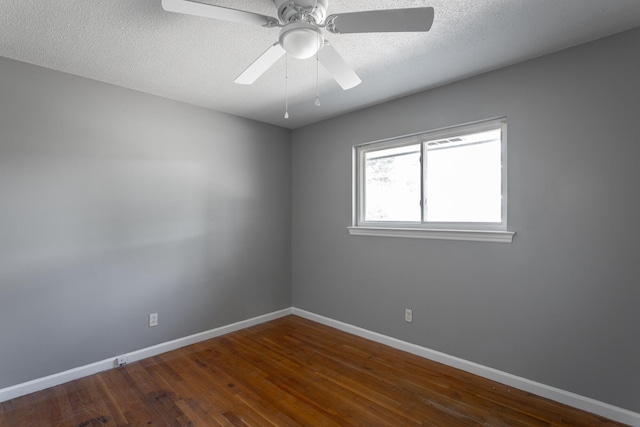 spare room with a textured ceiling, dark hardwood / wood-style floors, and ceiling fan