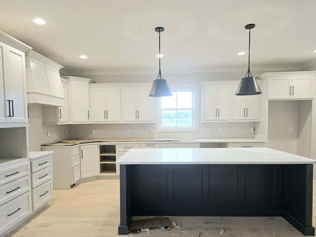 kitchen featuring hanging light fixtures, white cabinetry, a kitchen island, and light wood-type flooring