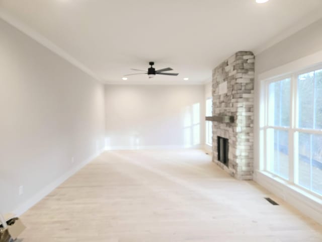 unfurnished living room with hardwood / wood-style flooring, ceiling fan, ornamental molding, and a fireplace