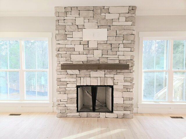 room details with hardwood / wood-style flooring and a stone fireplace