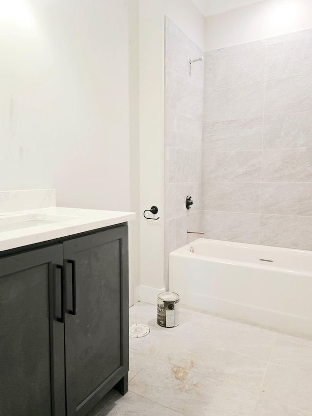 bathroom with tiled shower / bath combo, vanity, and tile patterned flooring