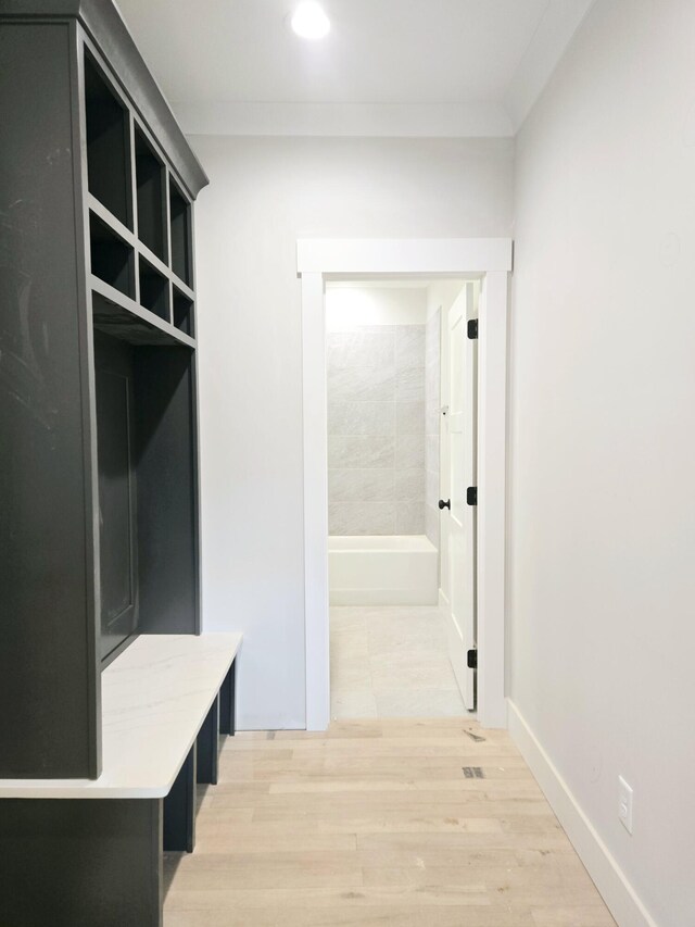 mudroom featuring ornamental molding and light wood-type flooring