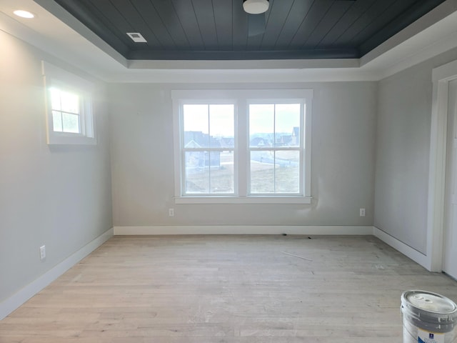 empty room with light hardwood / wood-style floors, wooden ceiling, and a raised ceiling