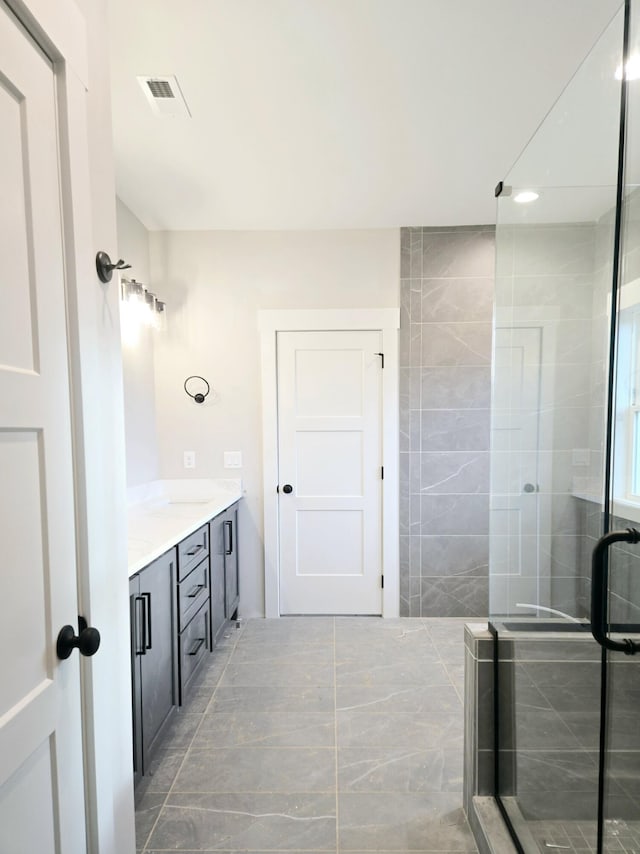 bathroom with vanity and a shower with shower door