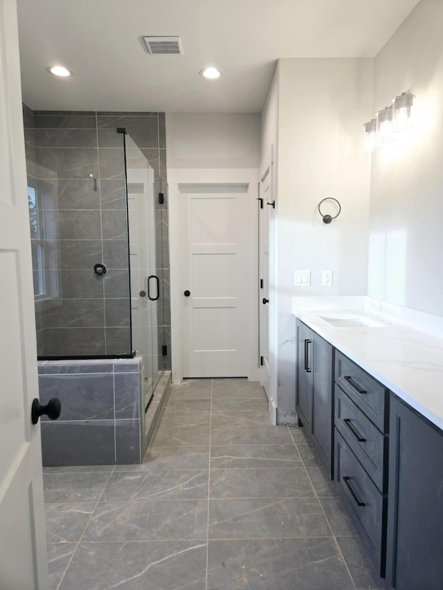 bathroom with vanity and a shower with door