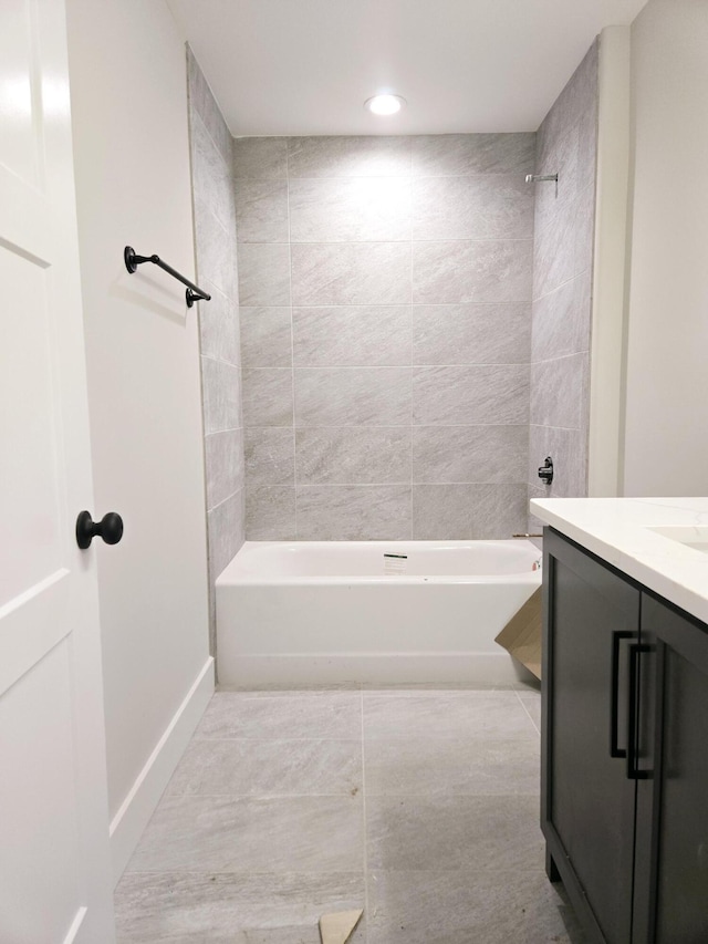 bathroom featuring tiled shower / bath combo, vanity, and tile patterned floors