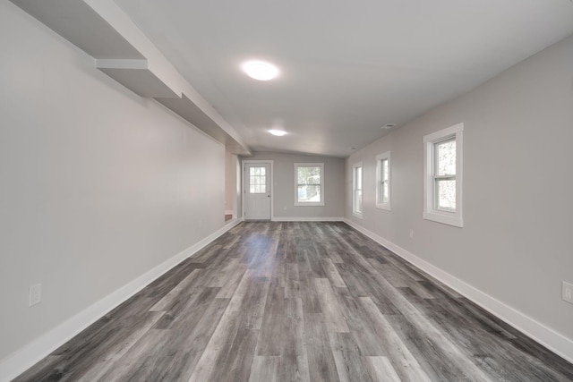 unfurnished room with lofted ceiling, dark hardwood / wood-style flooring, and a wealth of natural light