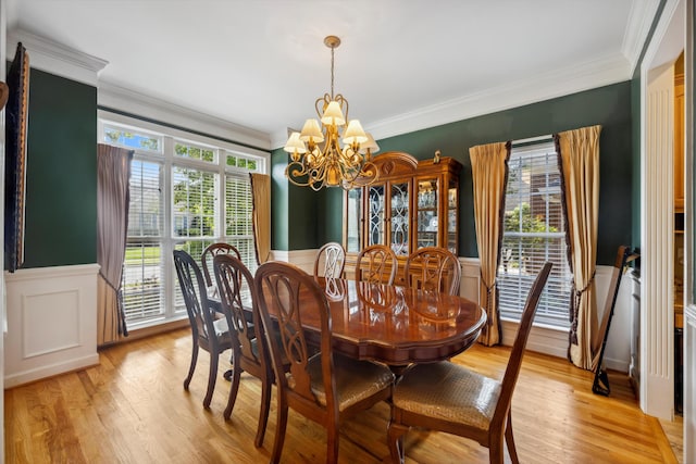 dining space featuring a notable chandelier, light hardwood / wood-style flooring, and ornamental molding