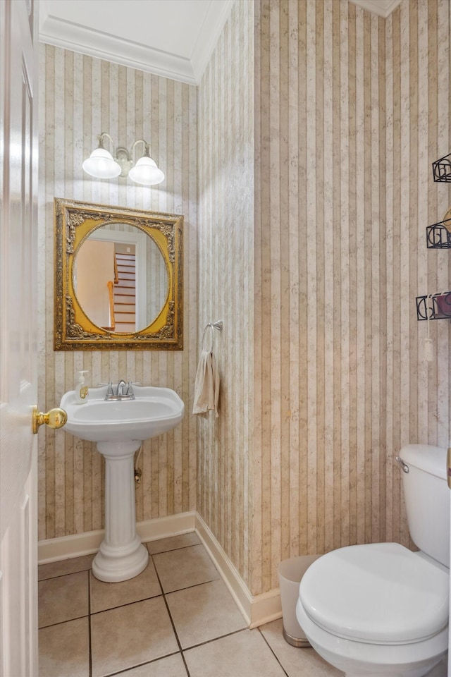 bathroom with tile patterned flooring, crown molding, and toilet