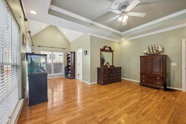 interior space featuring light wood-type flooring, crown molding, ceiling fan, and a raised ceiling