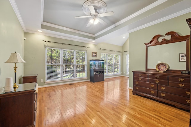 bedroom featuring light hardwood / wood-style flooring, a tray ceiling, ceiling fan, and ornamental molding