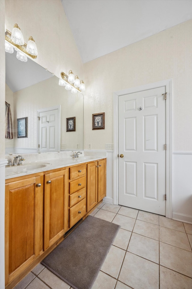 bathroom with vanity, vaulted ceiling, and tile patterned floors