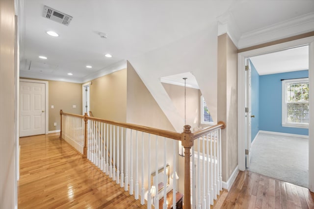 hallway with crown molding and light hardwood / wood-style floors