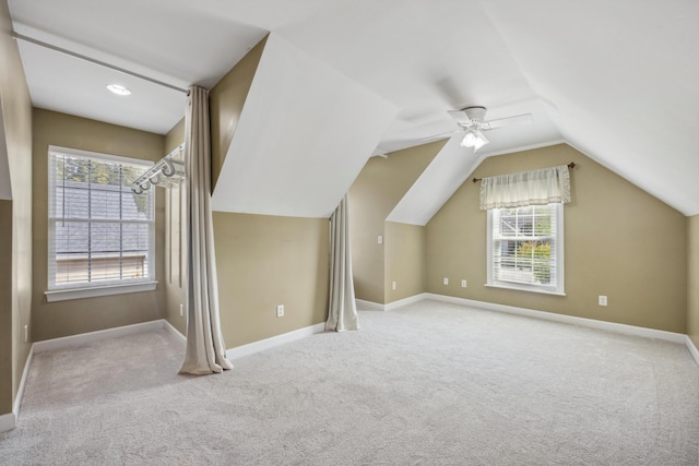 additional living space with lofted ceiling, light colored carpet, and plenty of natural light