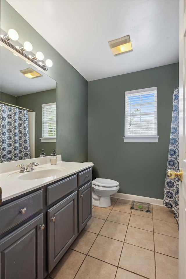 bathroom featuring tile patterned flooring, plenty of natural light, vanity, and toilet