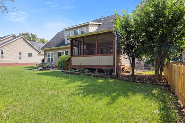 rear view of property with a sunroom and a yard